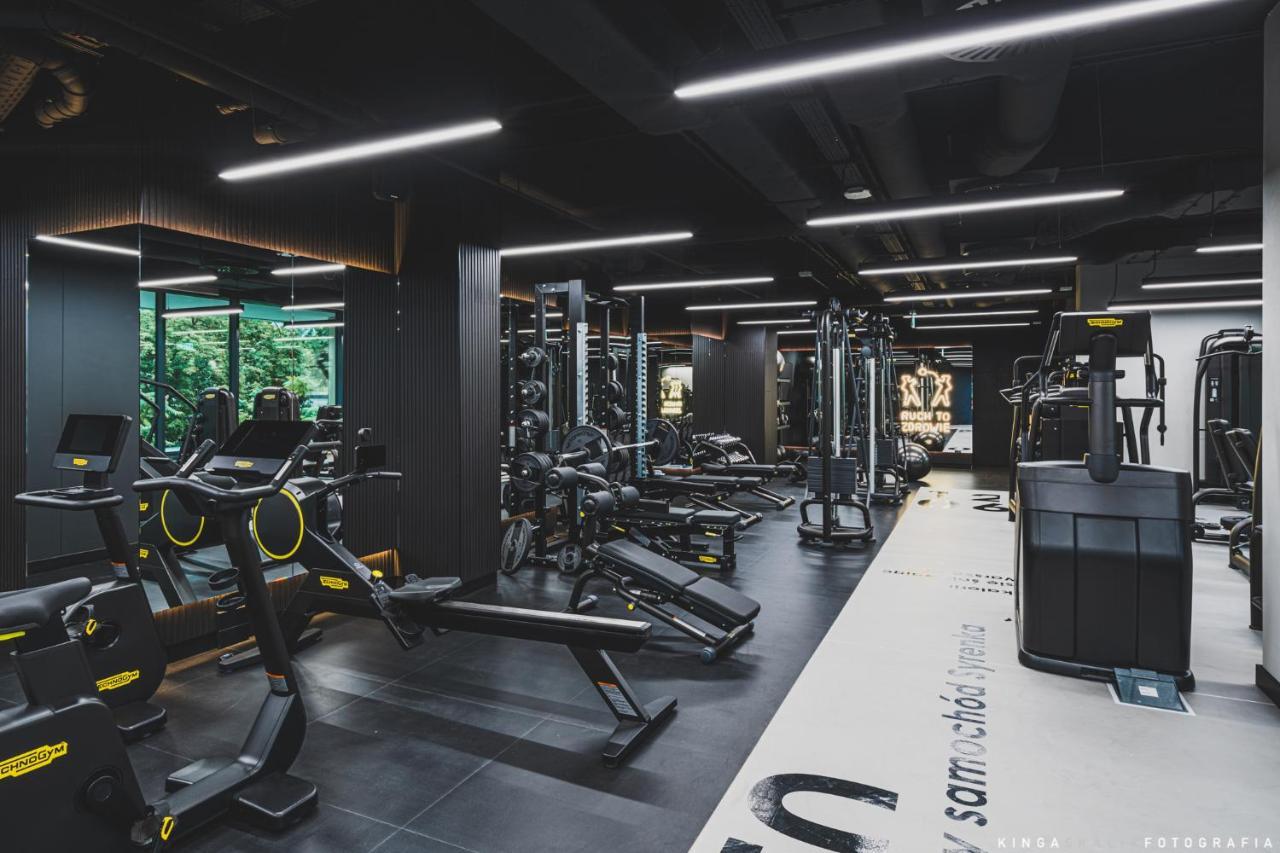 Royal Tulip Warsaw Centre Varsóvia Exterior foto The photo shows a modern gym interior with a sleek design. It features a variety of exercise equipment, including weight machines, free weights, and cardio machines. The space is well-lit with overhead lighting, and there are large windows allowing n