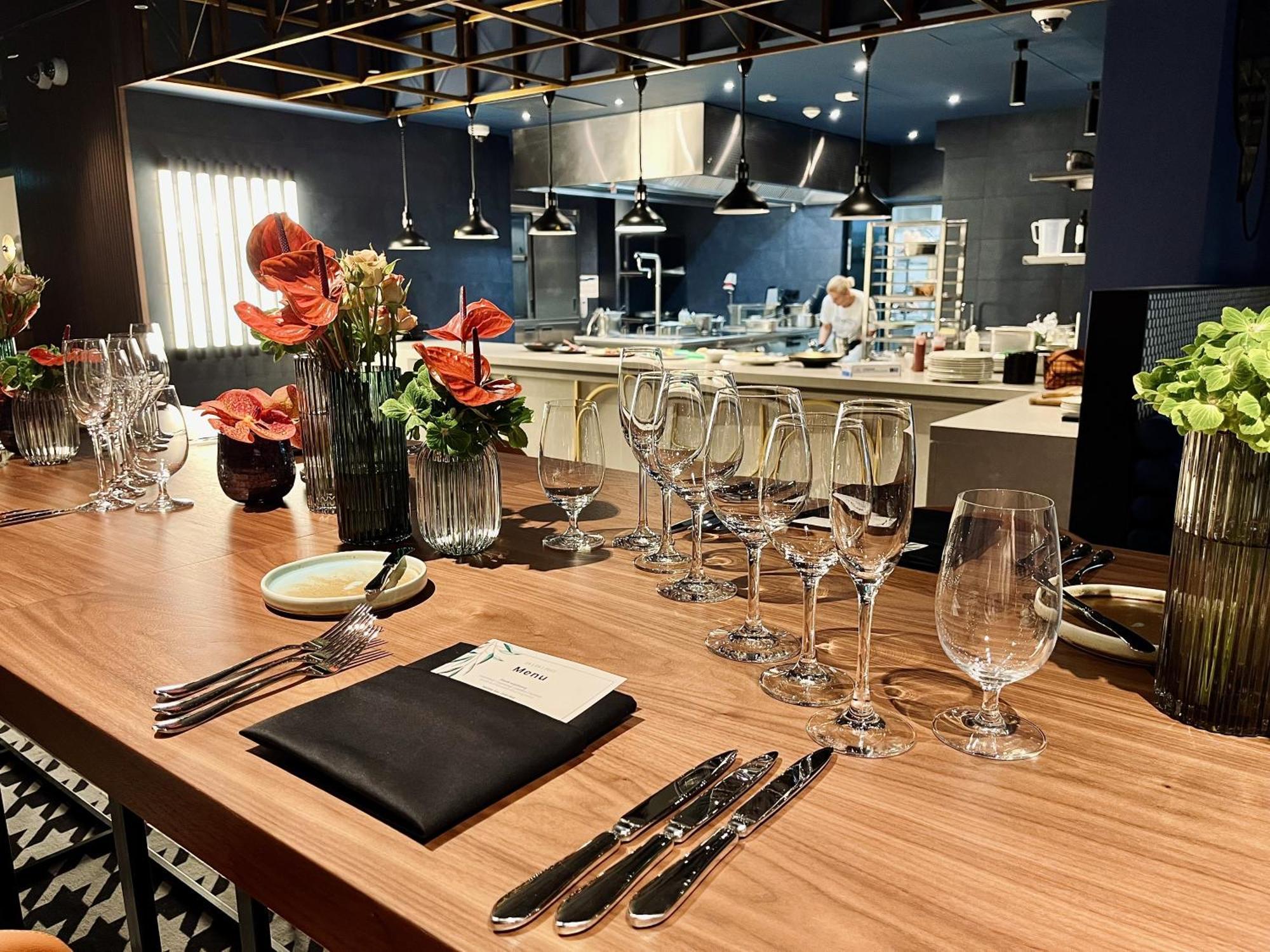 Royal Tulip Warsaw Centre Varsóvia Exterior foto The photo shows a beautifully arranged dining area in a restaurant. There is a long wooden table set with elegant glassware, including wine glasses and water glasses. Each place setting includes polished silverware and a folded napkin with a card on 